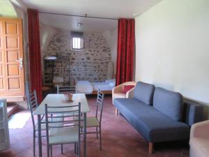 a living room with a couch and a table and chairs at Chez Bernard et Michèle in Manglieu