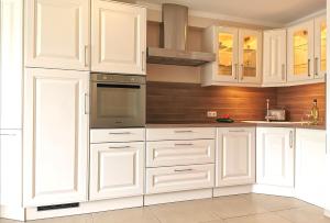 a white kitchen with white cabinets and a stove at Ferienhaus am Darß in Pruchten