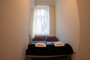 a small bed in a room with a window at Spacious Central Apartment in Vienna