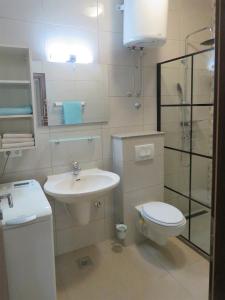 uma casa de banho branca com um lavatório e um WC em Apartmani Villa Delija Klek em Klek