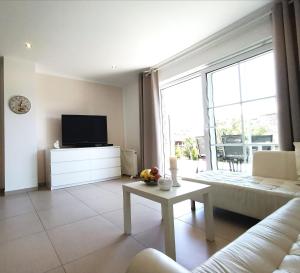 a living room with a couch and a tv at Ferienhaus am Darß in Pruchten