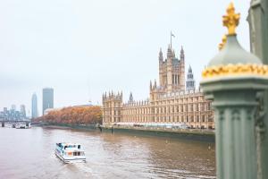 een boot in de rivier voor een groot gebouw bij Point A Hotel London Westminster in Londen