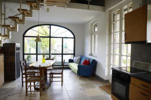 a kitchen with a table and a blue couch at Das alte Backhaus auf dem Bio-Bauernhof in Kevelaer