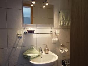 Baño blanco con lavabo y espejo en Hotel Waldterrasse, en Rengsdorf