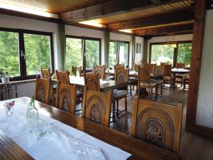 ein Esszimmer mit Tischen, Stühlen und Fenstern in der Unterkunft Hotel Waldterrasse in Rengsdorf