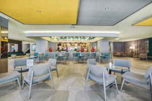 ein Restaurant mit Tischen und Stühlen und eine Bar in der Unterkunft Hotel Riu Festival in Playa de Palma