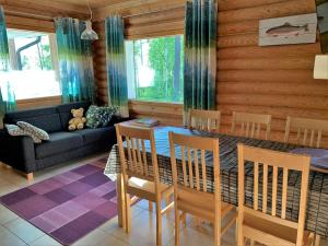ein Wohnzimmer mit einem Tisch, Stühlen und einem Sofa in der Unterkunft Lappalaisen lomamökit Mäntypirtti in Puumala