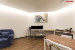 ein Wohnzimmer mit einem Schreibtisch mit zwei Monitoren und einem Sofa in der Unterkunft Hotel Yeogijoa in Gwangju