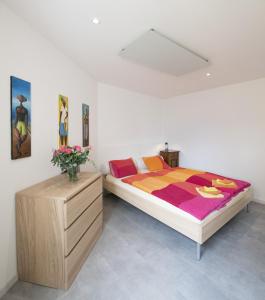 una camera con letto e cassettiera in legno di Casa Eva a Ronco sopra Ascona