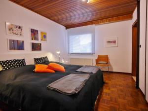 1 dormitorio con 1 cama negra grande con almohadas de color naranja en Komfort-Fewo Blickfang Willingen***, en Willingen 37 fotos más