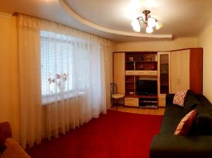 a living room with a couch and a large window at TOPILCHE APARTMENT in Ternopil