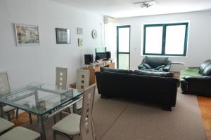 Una sala de estar con un sofá y una mesa de cristal. en Lasofti Vrnjacka Banja, en Vrnjačka Banja