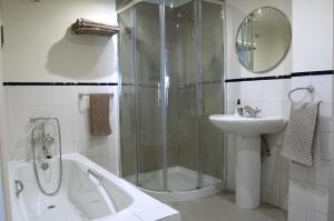 a bathroom with a shower and a tub and a sink at Apartamentos Ondoloin in Vitoria-Gasteiz
