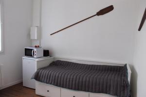 Schlafzimmer mit einem Bett und einer Mikrowelle an der Wand in der Unterkunft Résidence Pasteur - flyer in Rochefort