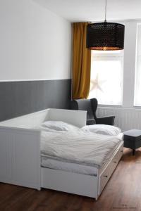een slaapkamer met een wit bed en een stoel bij Ferienwohnung "OTTO" in Erfurt