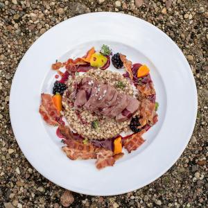 un plato blanco de comida con carne y verduras en Hotel Habenda en Budzyń