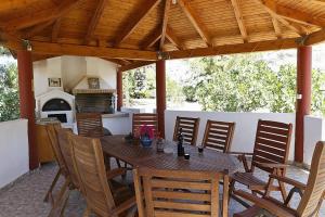 a wooden table and chairs on a patio at Villa Stamatis in Pefki