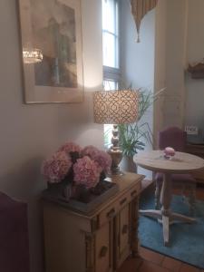 een kamer met een tafel en een lamp en bloemen bij Hotel Marmułowski in Wejherowo