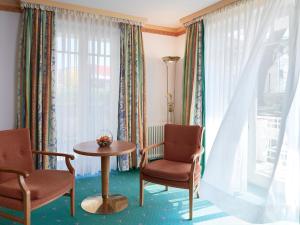 a room with two chairs and a table and a window at Travel Charme Nordperd & Villen in Göhren