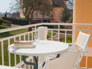 a white table and chairs on a balcony at Travel Charme Nordperd & Villen in Göhren
