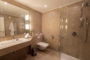a bathroom with a toilet and a sink and a shower at Strandhotel Fontana in Timmendorfer Strand +37 photos