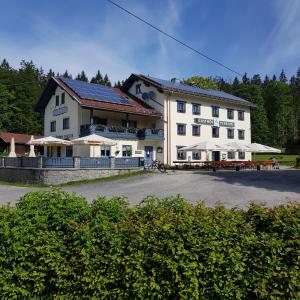 a large white building with tables and chairs in front of it at Zur Alten Dampfsäge - Gasthaus-Pension Weber in Lindberg