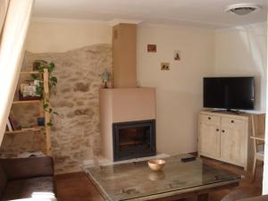 sala de estar con chimenea y TV en Casa Rural La Casita del Río, en Villarcayo