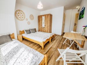 a bedroom with two beds and a table and chairs at Góralski Przystanek Jacuzzi & sauna - dom dla 17 osób in Biały Dunajec +119 photos
