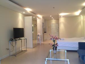 a room with a bed and a tv and a couch at View Talay 6 Pattaya Beach Apartment by Honey in Pattaya Central