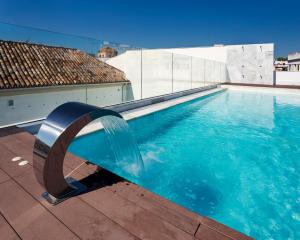 a swimming pool with a blue and white tub at One Shot Palacio Conde de Torrejón 09 in Seville