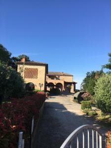 une route menant à une maison avec une clôture dans l'établissement Agriturismo Casale Giulia, à Volterra