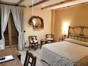 1 dormitorio con 1 cama, mesa y sillas en Hotel Rural & SPA Puente del Duratón, en Sepúlveda