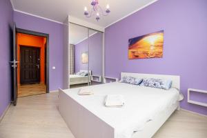 - une chambre violette avec un grand lit et un miroir dans l'établissement Apartment on Khakima 50, à Kazan