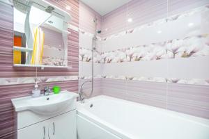 - une salle de bains rose avec baignoire et lavabo dans l'établissement Apartment on Khakima 50, à Kazan