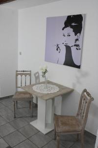 een tafel met twee stoelen en een schilderij aan de muur bij Ferienwohnung Martin in Eschwege