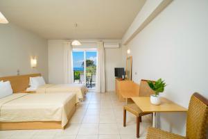 a hotel room with two beds and a balcony at Kohylia by La Scala Beach in Limenas