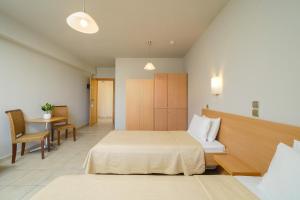 a hotel room with two beds and a table at Kohylia by La Scala Beach in Limenas