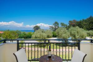 a table with a bottle of wine on a balcony at Kohylia by La Scala Beach in Limenas