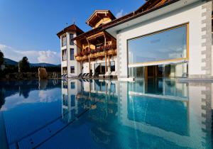 a large swimming pool in front of a house at Wellness & Naturhotel Tonihof in Langdorf