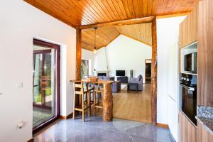 an open kitchen and living room with a wooden ceiling at Casa de Fundões - Gerês in Geres