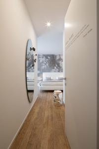 un soggiorno bianco con divano e specchio di B&B Le Farfalle a San Felice del Benaco