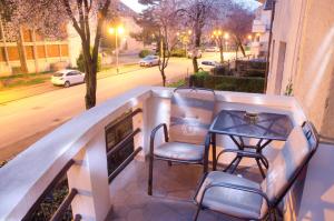 Un balcón con sillas, una mesa y una calle. en Apartment Cubo Maksimir 1 en Zagreb