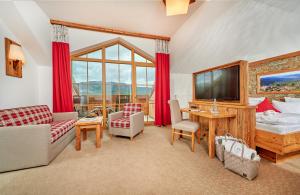 a living room with a large window and a tv at Wellness & Naturhotel Tonihof in Langdorf