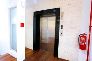 a elevator in a room with a fire extinguisher at Lux Hotel in Teluk Intan