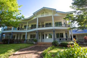 een groot wit huis met een balkon bij Diamond Hill Resort in Nong Nam Daeng