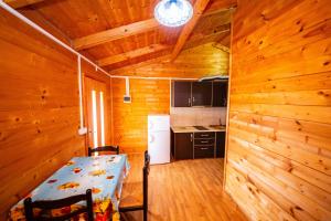 a kitchen with wooden walls and a table in a room at Guest House Luiza in Borsh