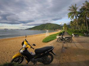 a motorcycle parked on a beach near the water at Hai Huong Hotel in Quy Nhon +38 photos