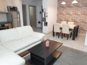sala de estar con sofá blanco y mesa en Uptown Residence Apartments, en Bucarest