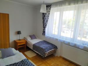 a small bedroom with a bed and a window at Dom gościnny Zosia in Świnoujście