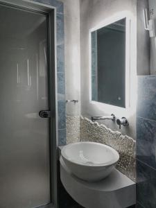 a bathroom with a white sink and a mirror at Haraki Village in Haraki